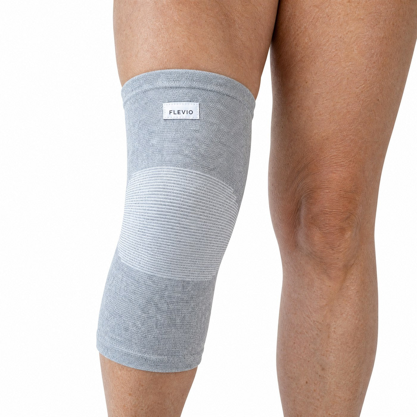 Genouillère de compression grise vue de profil sur une jambe tendue