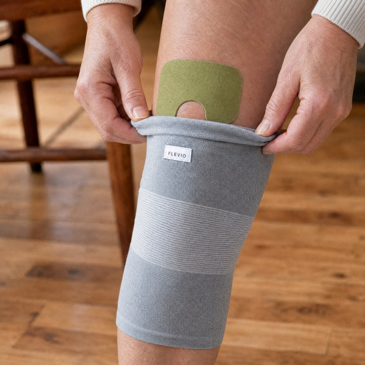 Patch chauffant glissé sous une genouillère de compression Flevio grise