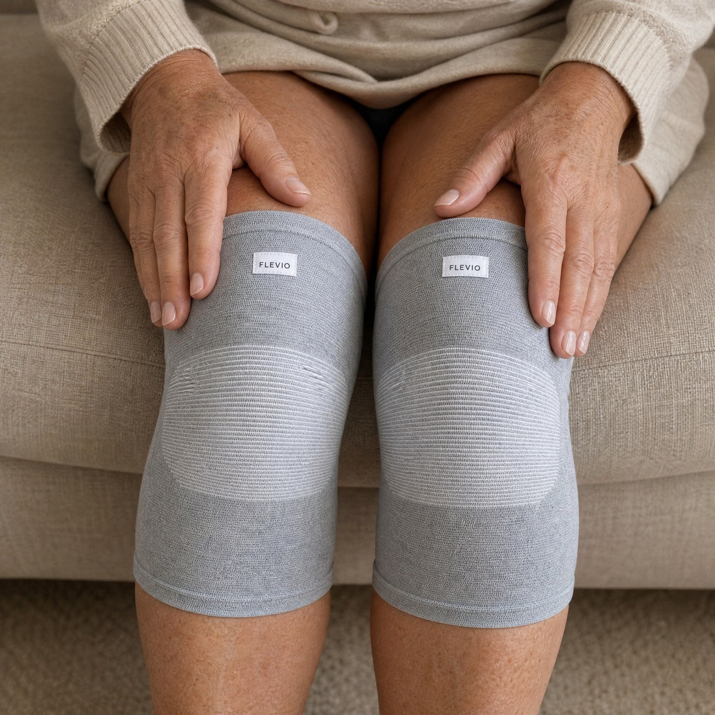 Femme assise portant une paire de genouillères de compression grises