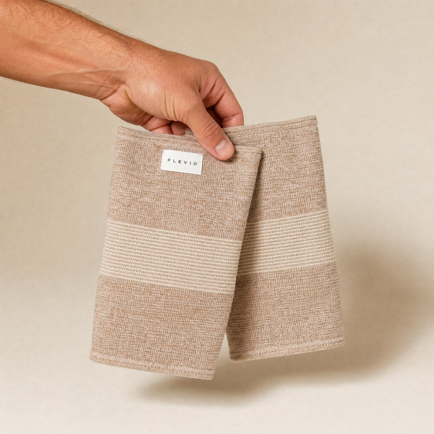 Paire de genouillères de compression Flevio beige tenue à la main