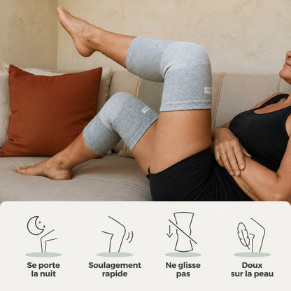 Femme allongée sur un canapé avec ses deux genouillères de compression grises